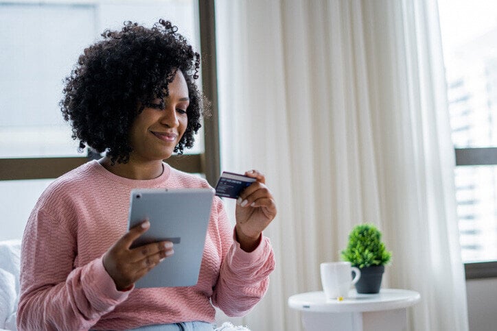 Photo of a happy woman looking at a credit card